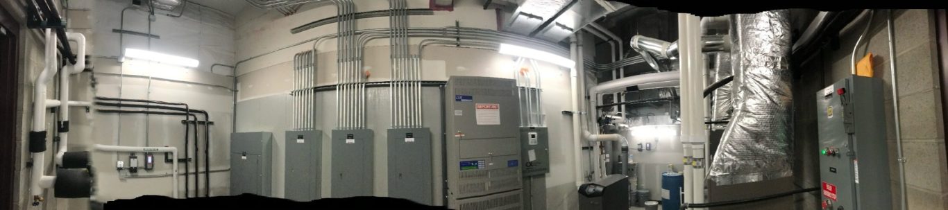 Panoramic view of an industrial facility with metal panels and equipment.